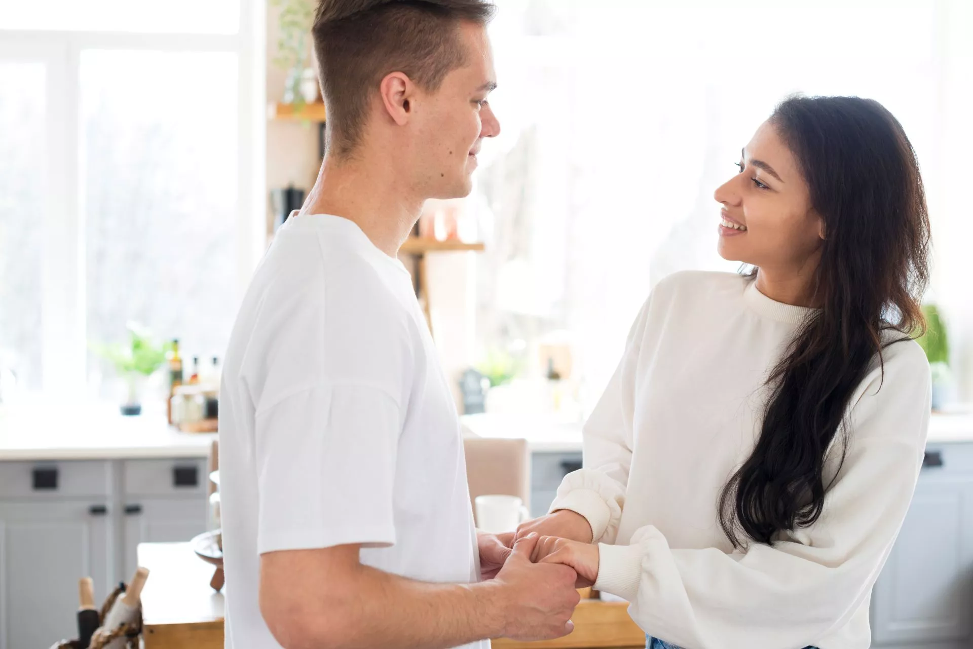 一對年輕男女在明亮室內空間中溫柔對視並牽著彼此的手，呈現甜心寶貝與成熟伴侶之間重視互動節奏、信任與情感交流的包養關係氛圍